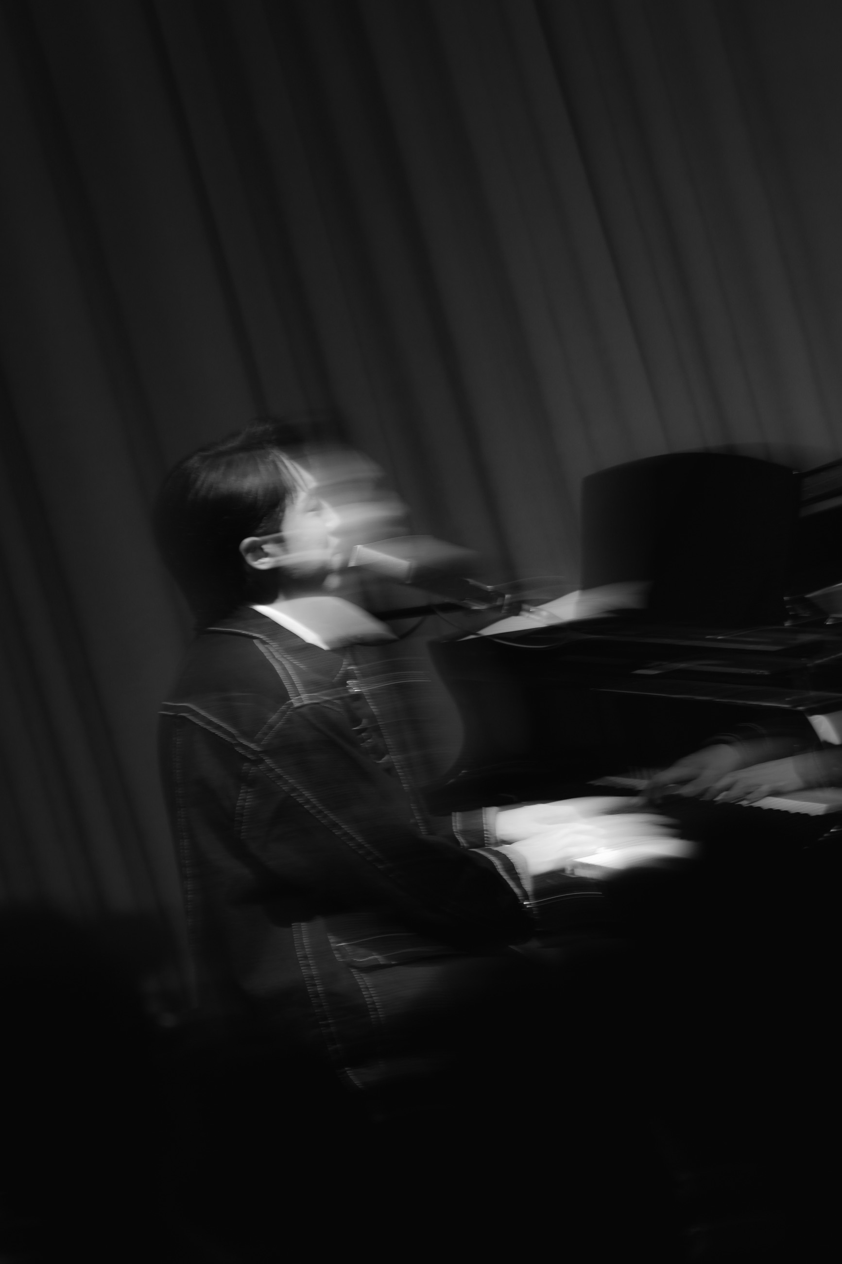 A monochrome motion portrait of the pianist performing
