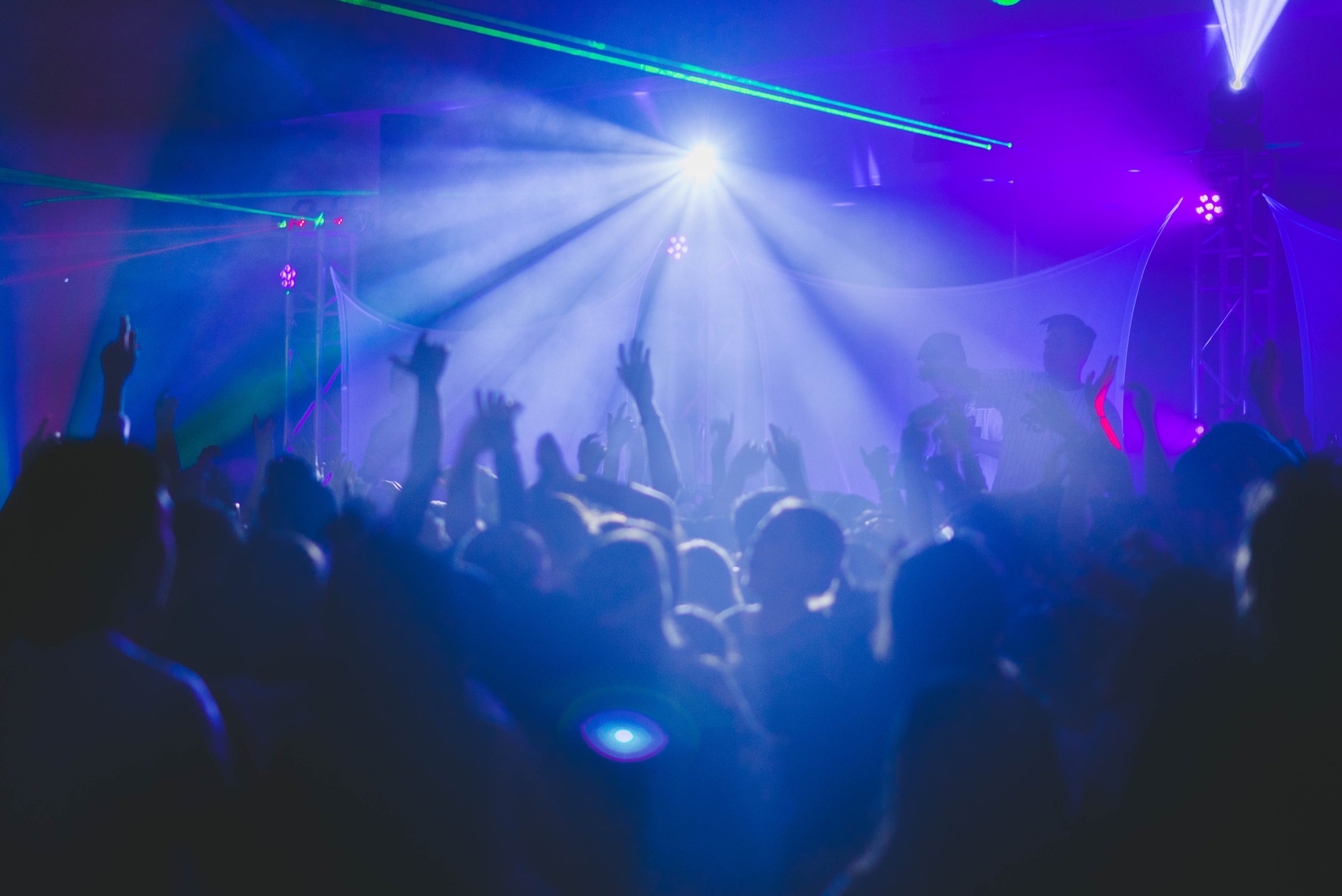 A live event crowd beneath blue and violet stage lighting