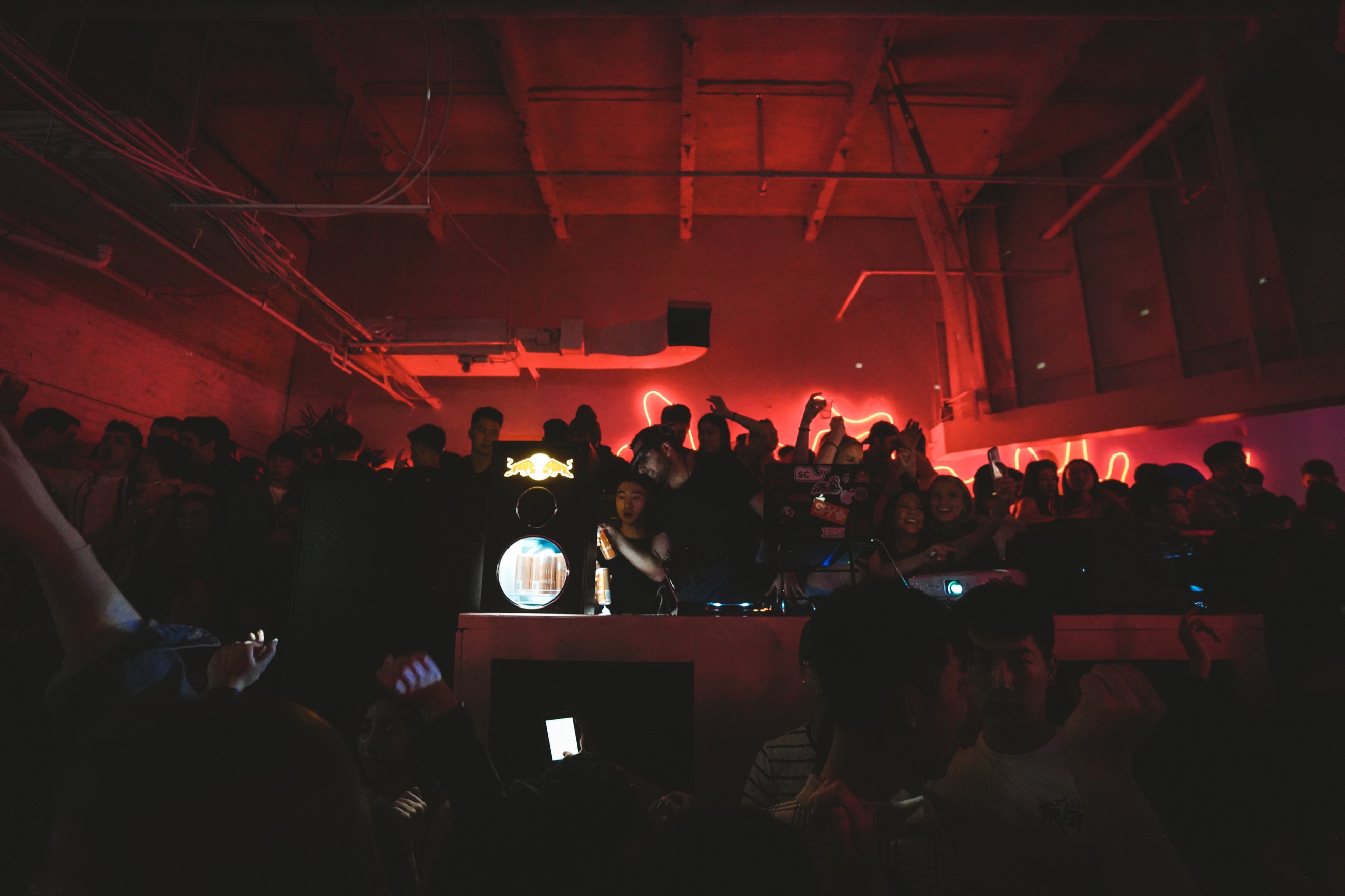 An energetic audience gathered under red light at the fashion show