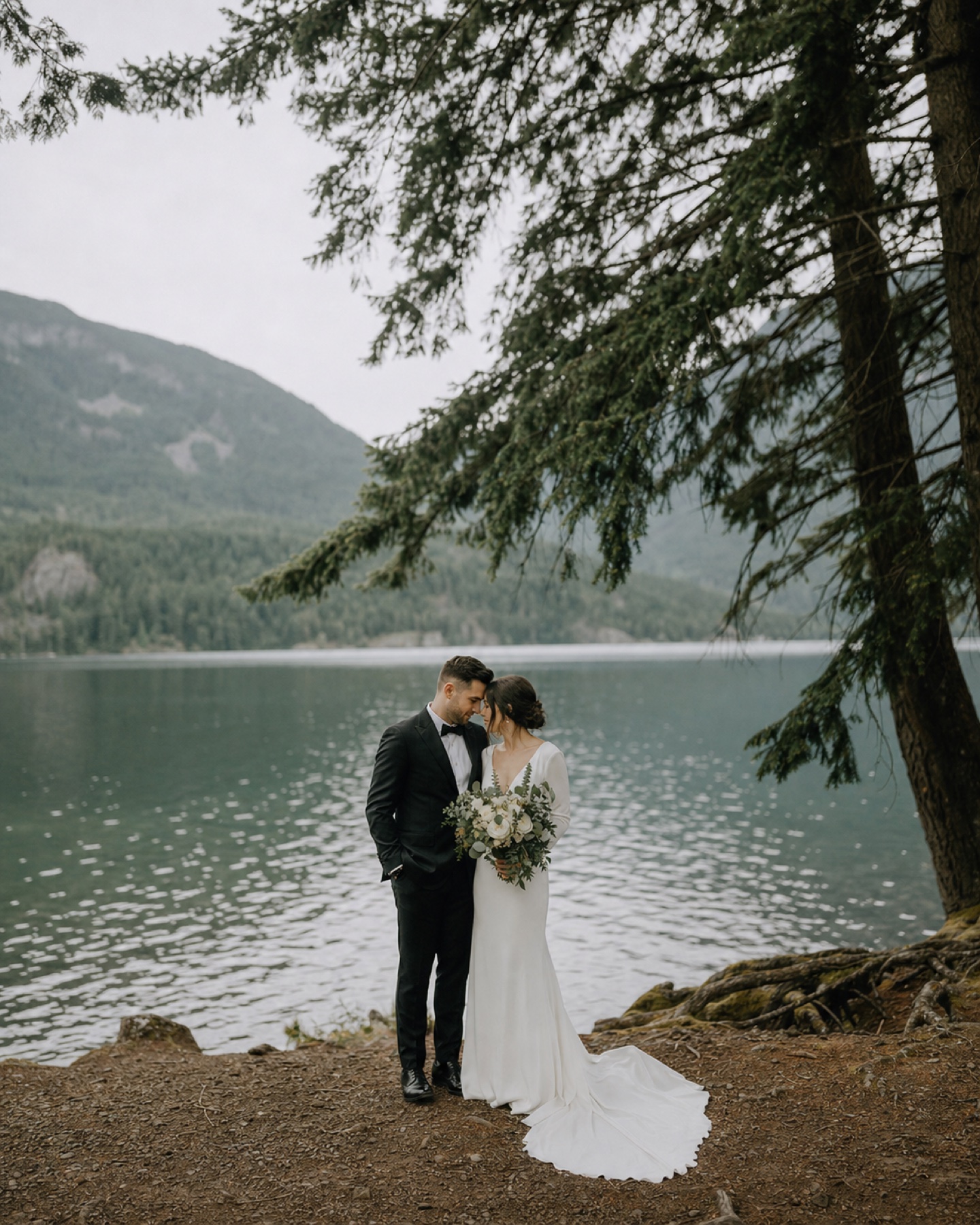 Newlyweds by a calm mountain lake