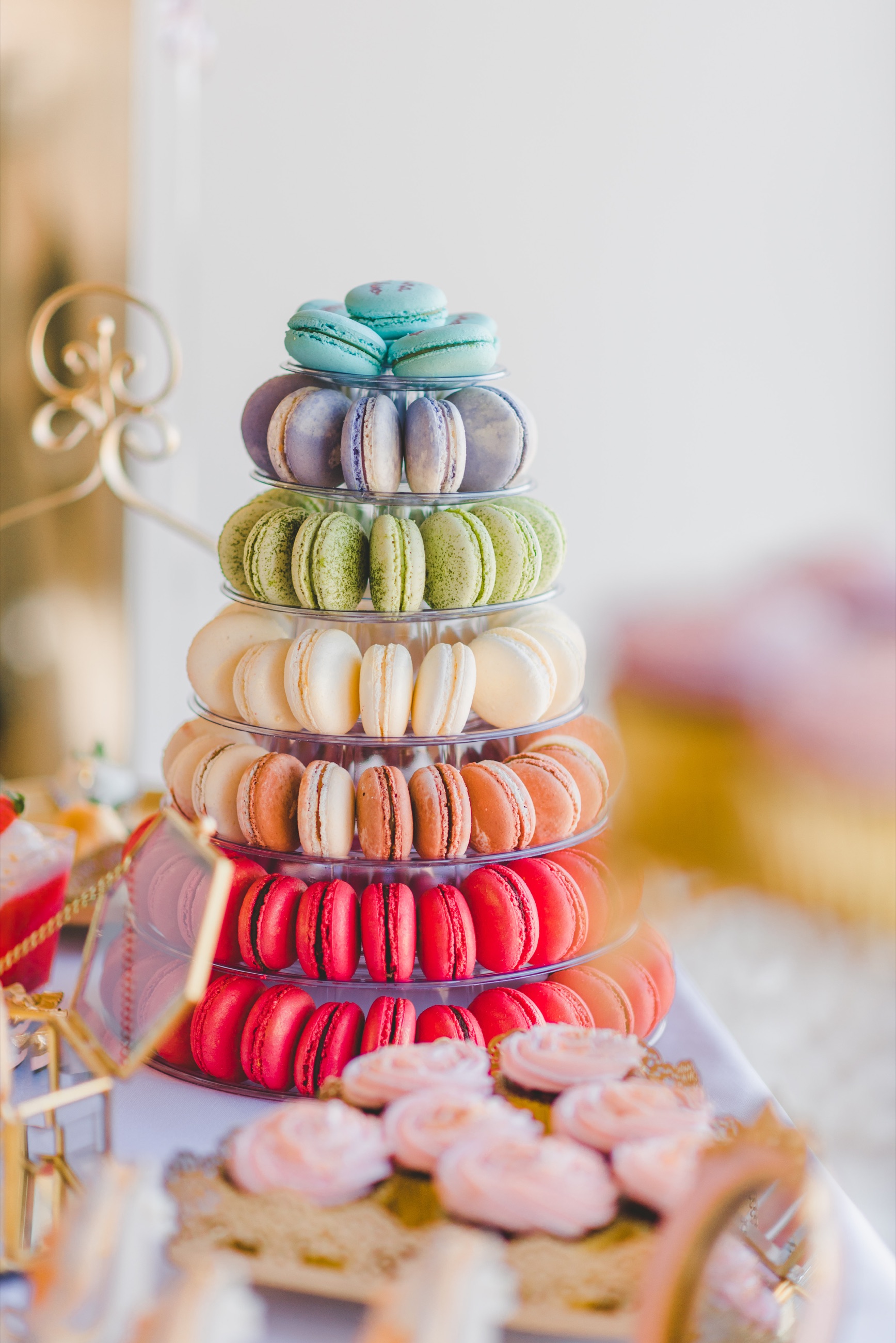 A colourful tiered macaron display prepared for a catered celebration