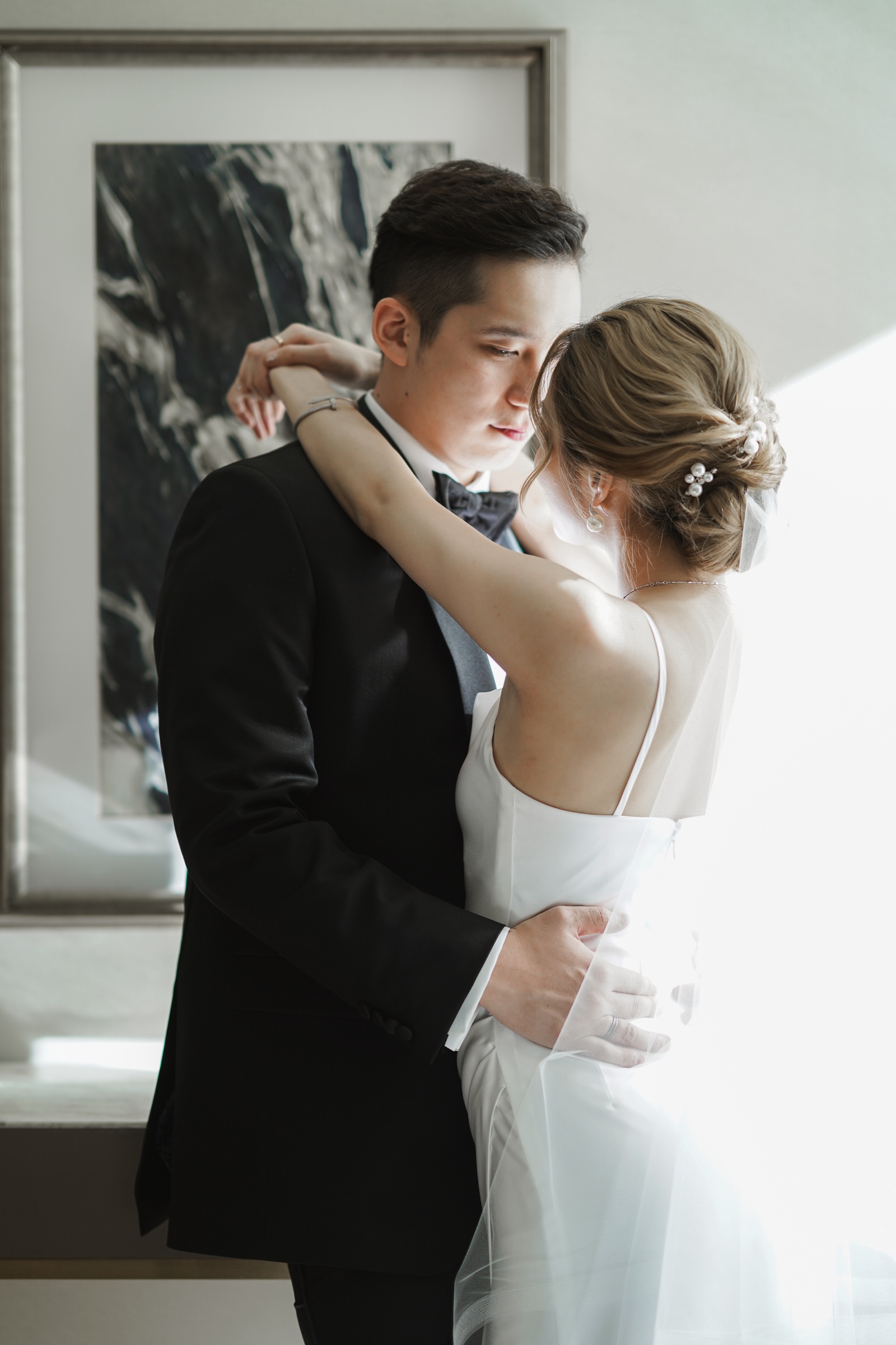 J and S embracing in soft window light